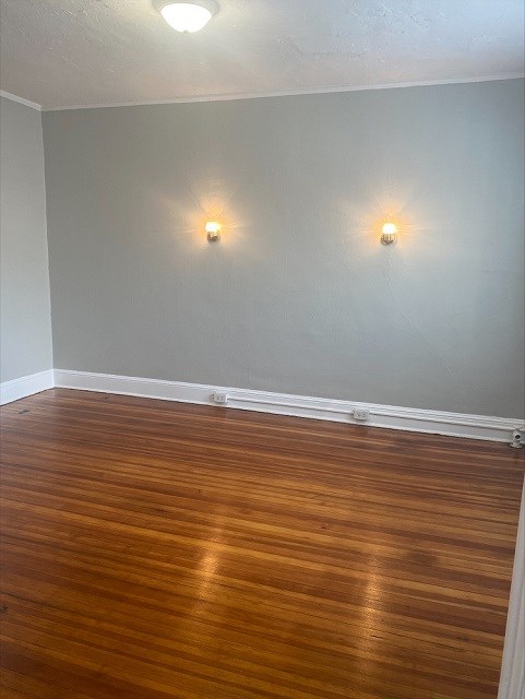 an empty room with wooden floors and two lights on the wall